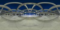 an indoor skate park with curved concrete arches and benches in the night sky above it