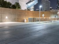 a person is riding on a skateboard down an empty street at night time in the city