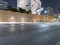 a person is riding on a skateboard down an empty street at night time in the city