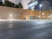 a person is riding on a skateboard down an empty street at night time in the city