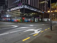 a view of a city street at night with a crosswalk in the foreground