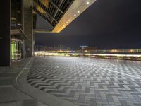 an empty open space with a few parking spaces next to it at night time with light streaks on the pavement