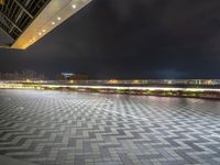 an empty open space with a few parking spaces next to it at night time with light streaks on the pavement