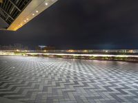 an empty open space with a few parking spaces next to it at night time with light streaks on the pavement