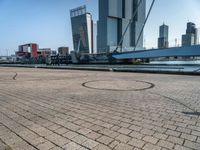 a bicycle is sitting on brick floor in front of city buildings at the beach area