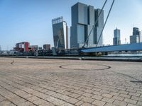 a bicycle is sitting on brick floor in front of city buildings at the beach area