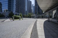 a person sitting at the bench in front of a mall that is empty of people