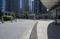 a person sitting at the bench in front of a mall that is empty of people