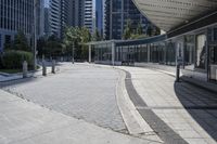 a person sitting at the bench in front of a mall that is empty of people