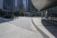 a person sitting at the bench in front of a mall that is empty of people