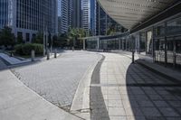 a person sitting at the bench in front of a mall that is empty of people