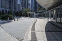 a person sitting at the bench in front of a mall that is empty of people