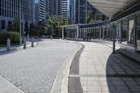 a person sitting at the bench in front of a mall that is empty of people