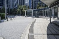 a person sitting at the bench in front of a mall that is empty of people