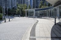 a person sitting at the bench in front of a mall that is empty of people