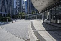 a person sitting at the bench in front of a mall that is empty of people