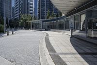 a person sitting at the bench in front of a mall that is empty of people