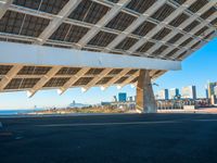 a building made out of solar panels in front of the ocean and a blue sky