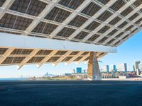 a building made out of solar panels in front of the ocean and a blue sky