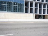 the front entrance of an office building at a crosswalk, with a street and a crosswalk in the background