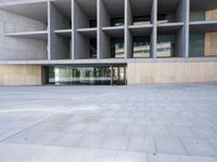 the building is made of concrete and has stone and glass accents, along with a curved staircase