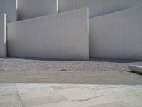 the gray concrete walls of a building have a line of steps on the left side