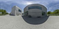 the image shows a fisheye lens view of a building with three people sitting on it