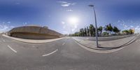 the view of an empty street from a fish - eye perspective mirror, showing two different angles