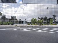 a picture taken of an empty road in front of an office building with a few palm trees