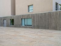 empty area outside concrete building with no people or vehicles at the entrance to area behind it