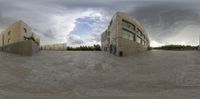 a fish eye view of several buildings in a public plaza with a ramp on one side and a skateboarder and a building to the other