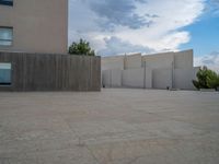 empty area outside concrete building with no people or vehicles at the entrance to area behind it