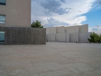 empty area outside concrete building with no people or vehicles at the entrance to area behind it