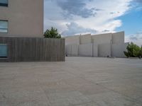 empty area outside concrete building with no people or vehicles at the entrance to area behind it