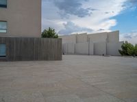 empty area outside concrete building with no people or vehicles at the entrance to area behind it