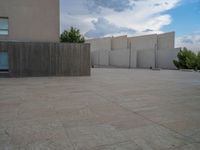 empty area outside concrete building with no people or vehicles at the entrance to area behind it