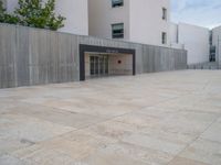 empty area outside concrete building with no people or vehicles at the entrance to area behind it