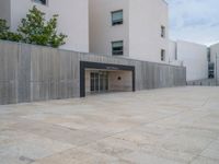 empty area outside concrete building with no people or vehicles at the entrance to area behind it