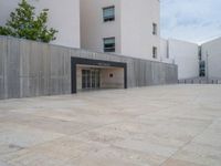 empty area outside concrete building with no people or vehicles at the entrance to area behind it