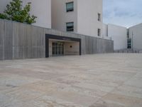 empty area outside concrete building with no people or vehicles at the entrance to area behind it