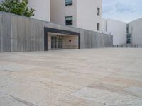 empty area outside concrete building with no people or vehicles at the entrance to area behind it