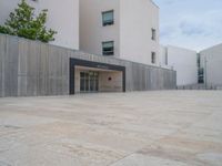 empty area outside concrete building with no people or vehicles at the entrance to area behind it