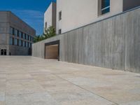 the gray concrete walls of a building have a line of steps on the left side