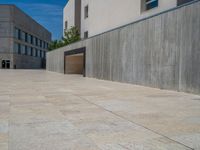 the gray concrete walls of a building have a line of steps on the left side