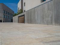 the gray concrete walls of a building have a line of steps on the left side