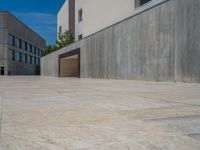 the gray concrete walls of a building have a line of steps on the left side