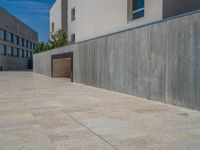 the gray concrete walls of a building have a line of steps on the left side