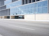 a large building with many windows is on the corner of the street near a highway