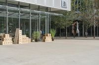 a store front with large windows, plants and cardboard boxes stacked on the floor outside