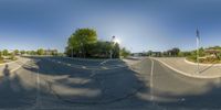 this is a very empty street with a big bright sun in the background as seen from a fish eye view